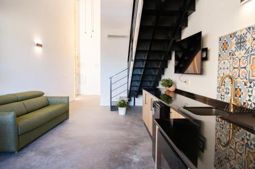 sala de estar con sofá verde y cocina en Apartamentos BocairentHomes, disfruta en pleno centro de Bocairent, en Bocairent