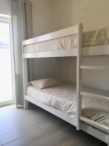 a white bunk bed in a room at Torrezinha- Moradia Moderna em condomínio com piscina in Salir de Porto