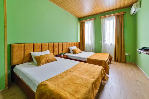 two beds in a room with green walls at Zedazeni Hotel in Mtskheta