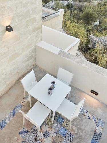 a white table and two white chairs on a patio at Villa Rocce Bianche in Favignana