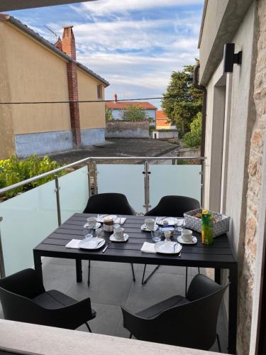 a table on a balcony with a table and chairs at Apartment MM22 in Peroj