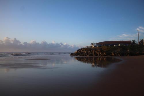 a view of a beach with a building and the ocean at Recanto do Rey in Mucuri