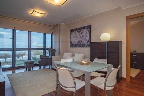 ヒホンにあるBahia Apartamentoのダイニングテーブルと椅子のあるリビングルーム