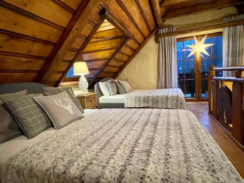 a bedroom with two beds and a large window at Domek na Cuplu - opcjonalnie balia jacuzzi in Szczyrk