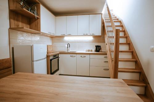 a kitchen with a staircase leading up to a kitchen with white appliances at Apartments Čenda in Železniki