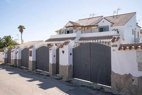 uma cerca em frente a uma casa branca em Mi pequeño rincón em Los Caños de Meca
