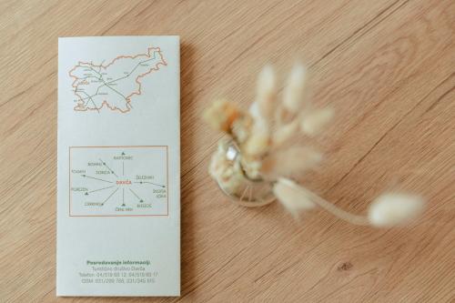 a card next to a flower on a table at Apartments Čenda in Železniki
