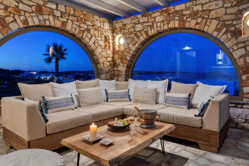 a living room with a couch and a table at Amalgam Homes Paros in Ambelas