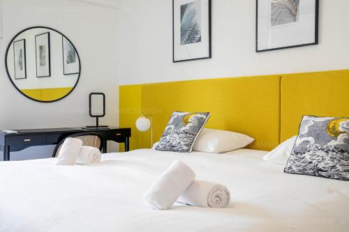 - une chambre avec 2 lits et une tête de lit jaune dans l'établissement Palais Azur, à Cannes