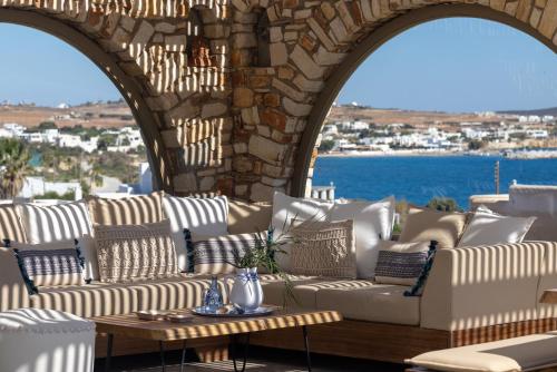 a patio with white couches and a table at Amalgam Homes Paros in Ambelas