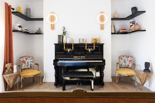 a black piano in a room with two chairs at Lugar do Ourives Boutique Hotel in Febres