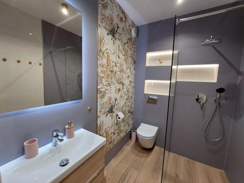 a bathroom with a toilet and a sink and a shower at Apartament Pod Papugami 2 Karpatia Resort in Karpacz
