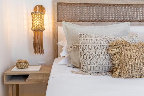a bedroom with a bed with pillows and a table at Amalgam Homes Paros in Ambelas
