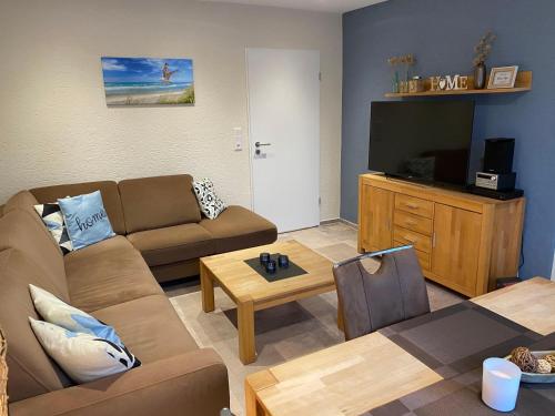 ein Wohnzimmer mit einem Sofa und einem TV in der Unterkunft Ferienwohnung Am Südstrand in Borkum