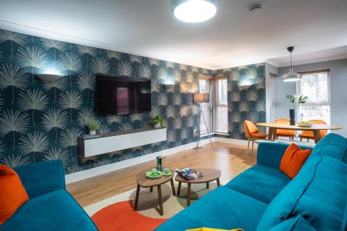 a living room with a blue couch and a tv at All Saints House in Worcester