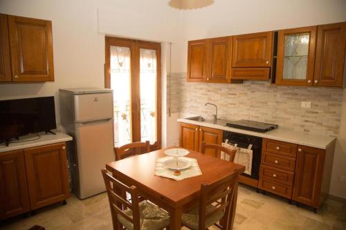 a kitchen with wooden cabinets and a table and a refrigerator at Delicious Holiday Home in Trappeto