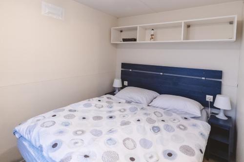 Schlafzimmer mit einem großen Bett mit blauem Kopfteil in der Unterkunft Holiday cottage II with 2 Thermal Riviera Tickets in Moravske-Toplice