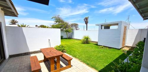 a backyard with a wooden bench and a fence at Tiende Laan Bed & Breakfast and Self-Catering in Walvis Bay