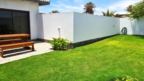 a backyard with a bench and a grass yard at Tiende Laan Bed & Breakfast and Self-Catering in Walvis Bay
