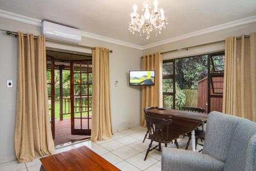 ein Wohnzimmer mit einem Billardtisch und einem Kronleuchter in der Unterkunft Kangelani Lodge in Hillcrest