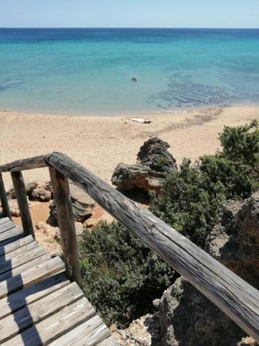 a wooden staircase leading to a beach with the ocean at Masseria a libeccio in Maruggio