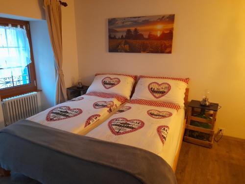a bedroom with two beds with hearts on the sheets at Studio chez un vigneron au village in Villeneuve