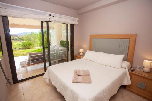 a bedroom with a bed and a balcony with a television at Vera-Mojácar Valle del Este Resort Golf & SPA in Vera