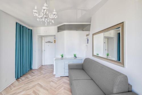 een woonkamer met een bank en een spiegel bij Le Milady- Versailles in Versailles