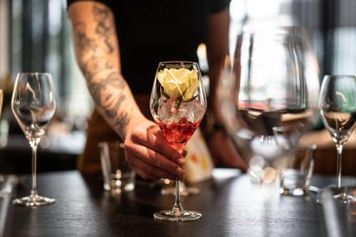 a man holding a wine glass with a diamond in it at Hotelli Olof in Tornio