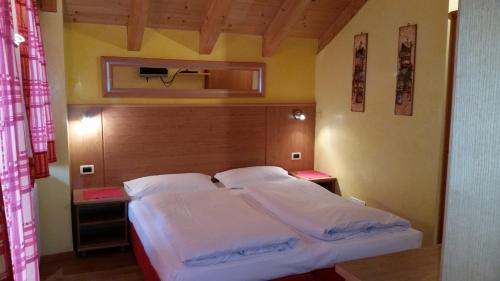a bedroom with a bed with a wooden head board at Chalet Heidi in Arabba