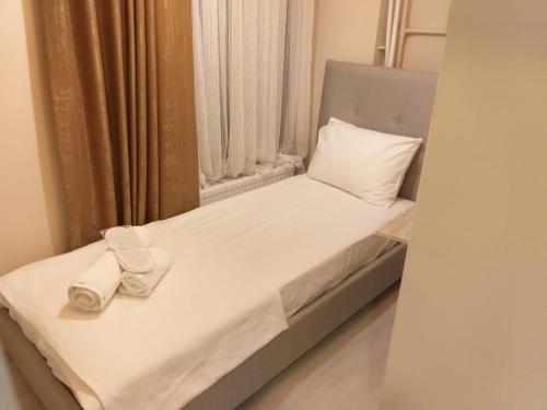 Un pequeño dormitorio con una cama con toallas blancas. en Private Room in Istanbul #23, en Estambul