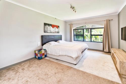 a bedroom with a bed and a large window at Modern 4 bedroom residential villa with pool, fully solar powered in Sandton