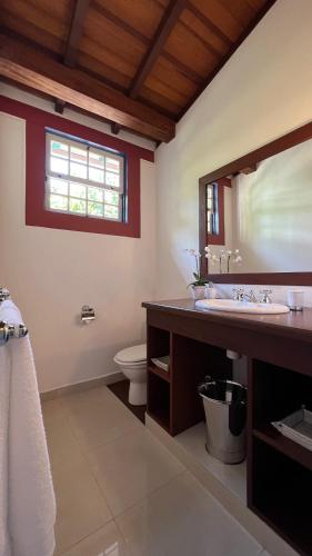 a bathroom with a sink and a mirror at Casa Beijaflor in Paraty