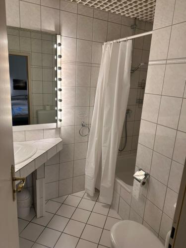 a bathroom with a shower and a toilet and a sink at Hotel "dream in" Heiligenhaus in Heiligenhaus
