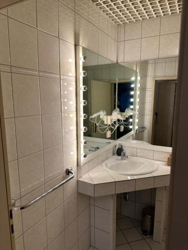 La salle de bains est pourvue d'un lavabo et d'un miroir. dans l'établissement Madisson green "dream in", à Heiligenhaus