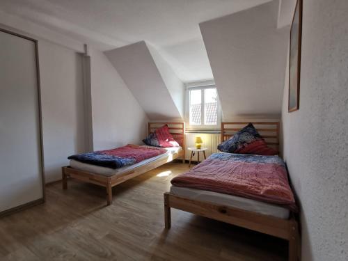 een slaapkamer met 2 bedden op een zolder bij Pension zum Hirsch in Hattersheim