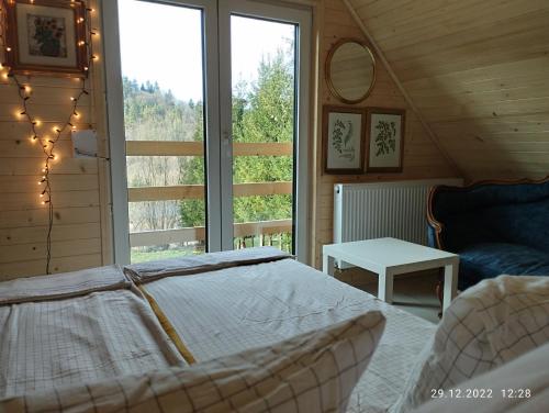 a bedroom with a bed and a large window at Bystre Chaty in Bystre