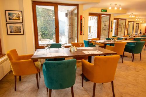a dining room with wooden tables and chairs at Hotel Alpinist, Malyovitsa in Govedartsi