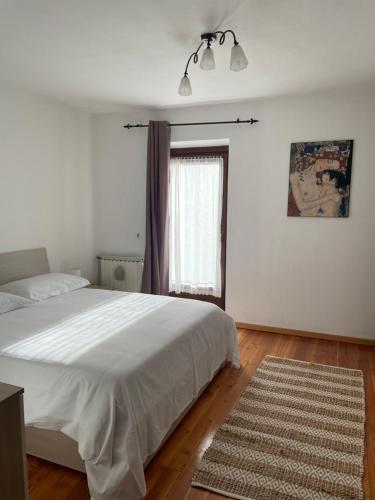 a bedroom with a white bed and a window at AMPAILLAN002 in Aosta