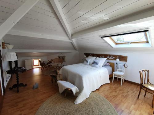 a bedroom with a white bed in a attic at LA VIE EST BELLE 