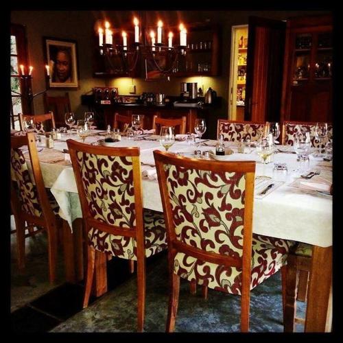 a dining room table with a white table cloth and chairs at Utopia in Africa Guest Villa in Nelspruit