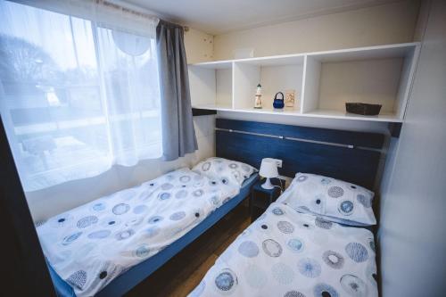 ein kleines Zimmer mit 2 Betten und einem Fenster in der Unterkunft Holiday cottage II with 2 Thermal Riviera Tickets in Moravske-Toplice