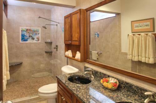 a bathroom with a sink and a toilet and a mirror at Gallows Point Resort in Saint John
