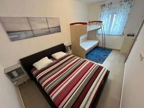 Apartment Lucija في سيموني: غرفة نوم صغيرة بها سرير ودرج
