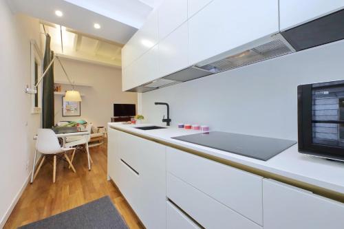 a kitchen with white cabinets and a counter top at 4BNB - Serpenti Delightful Apartment in Rome