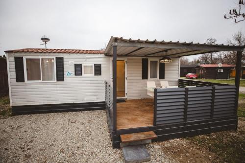 a white tiny house with a pergola at Holiday cottage II with 2 Thermal Riviera Tickets in Moravske Toplice