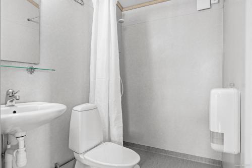 La salle de bains blanche est pourvue de toilettes et d'un lavabo. dans l'établissement First Camp Skutberget-Karlstad, à Karlstad