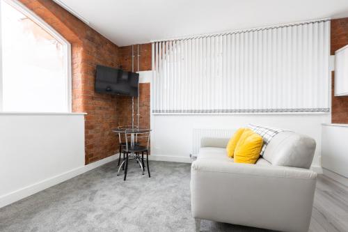 a living room with a white couch and a tv at 1 Bed City Studio near Theatre and Station Secure Parking in Hull