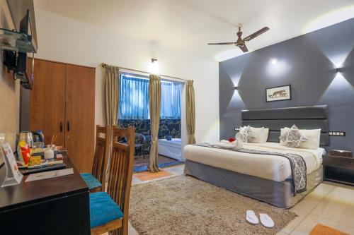 a hotel room with a bed and a desk and a bedroom at The Blossom Resort - Chikmagalur in Chikmagalūr