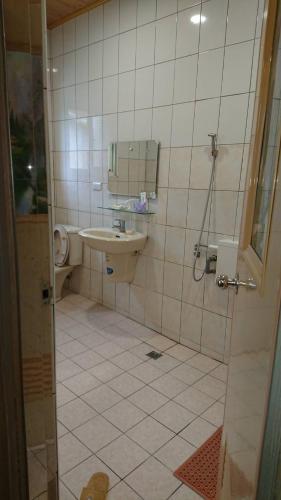 a bathroom with a sink and a toilet and a shower at Ming Camphor Homestay in Meishan